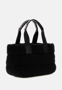 Czarna torba na ramię z miękkiego, teksturowanego materiału z grubymi bocznymi panelami. Posiada krótkie, solidne czarne uchwyty i eleganckie skórzane wykończenia.