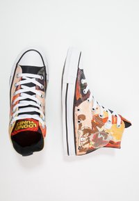 Vysoké tenisky s barevnými kreslenými grafikami, převážně černé a oranžové, s bílými tkaničkami, gumovou podešví a detailem loga na jazyku.