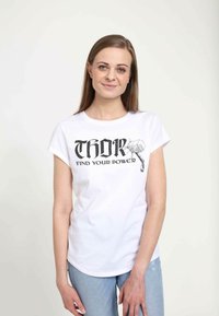 Bílý tričko s krátkým rukávem, které má černý grafický potisk "THOR" a kladivo s textem "NAJDI SVOU SÍLU." Jednoduchý kulatý výstřih.