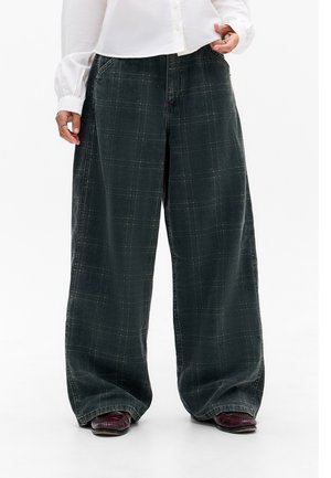 Wide-leg plaid pants in dark green corduroy. Features a soft texture, large side pockets, and subtle yellow and white check patterns.