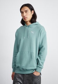 Felpa verde menta in cotone misto. Caratterizzata da una tasca a marsupio, cappuccio regolabile con coulisse e un piccolo logo bianco sul petto.