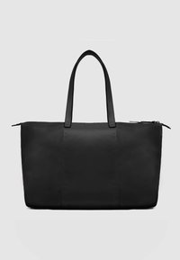 Zwarte nylon draagtas met dubbele leren handvatten, ritssluiting en een gladde matte textuur. Heeft een minimalistisch rechthoekig ontwerp.