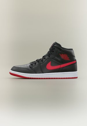Pantof sport înalt negru și roșu cu șireturi negre, siglă Nike roșie și talpă albă cu model roșu, prezentat în profil pe fundal neutru.