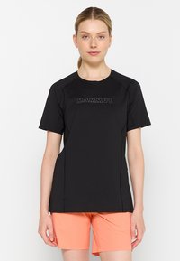 Svart t-shirt med kort ärm och raglanärmar, med en tryckt "MAMMUT"-logotyp över bröstet, tillverkad av lättviktigt tyg.