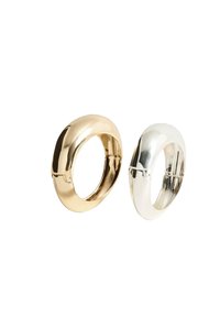 Zlatni i srebrni metalni prstenovi s zaobljenim oblicima, s glatkim, reflektirajućim završetkom i kopčom na jednoj strani.