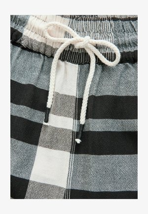 Melna un balta raibām šortiem ir elastīga josta un balta aukla. Audumam ir teksturēta virsma ar kontrastējošām līnijām.