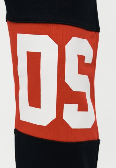 Κοντινό πλάνο κόκκινου και μαύρου υφάσματος με μεγάλο λευκό αριθμό "05" τυπωμένο στην κόκκινη περιοχή.