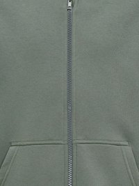 Felpa verde con zip realizzata in tessuto testurizzato, dotata di tasche a marsupio e un sottile dettaglio di cucitura lungo il fronte e i bordi delle tasche.