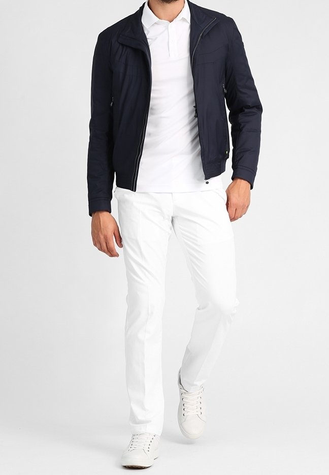 Námořnická lehká bomber bunda se zipem, v kombinaci s bílým polo tričkem a slim-fit bílými kalhotami. Dokončeno bílými teniskami.
