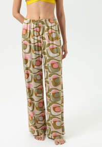 Weite Lounge-Hose aus leichtem Stoff mit einem mehrfarbigen geometrischen Muster in Grün-, Rosa- und Brauntönen. Elastischer Bund.