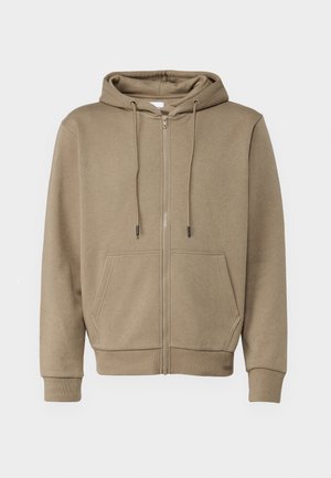 Tanka zip-up dukserica napravljena od mekog materijala, s kapuljačom, dvije prednje džepove i rebrastim rubovima na rukavima i donjem dijelu.