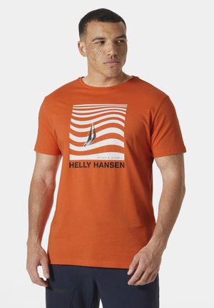 Oranje katoenen t-shirt met een bootafbeelding omgeven door golvende lijnen en de tekst "HELly Hansen" in vetgedrukte zwarte letters.