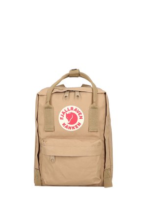 Petit sac à dos beige Fjällräven Kånken avec deux poignées supérieures, poche avant et écusson rond rouge avec logo à l'avant au centre.
