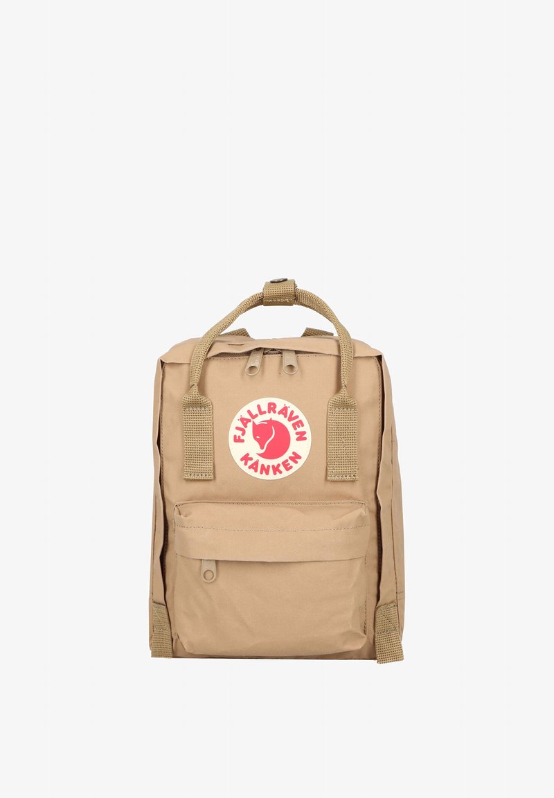 Μικρό μπεζ σακίδιο Fjällräven Kånken με δύο πάνω λαβές, μπροστινή τσέπη και στρογγυλό κόκκινο λογότυπο στο κέντρο μπροστά.