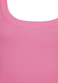 Roze tanktop met een geribbelde structuur, ronde halslijn en een aansluitend ontwerp met rechte randen. De stof lijkt lichtgewicht en zacht te zijn.