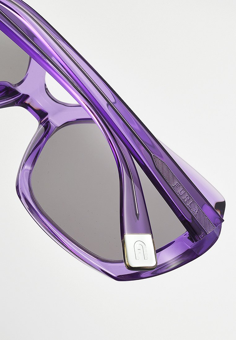 occhiali da sole viola traslucidi con lenti grigie, dotati di un accento metallico e dettagli del marchio sulle astine.