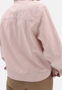 Jasnoróżowa bawełniana kurtka o luźnym kroju, z tylnym szwem yoke i mankietami na guziki. Gładka faktura, minimalistyczny design.