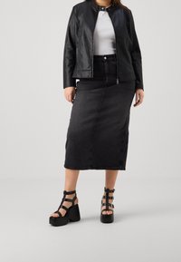 Black faux leather jacket over a white top, paired with a black denim midi skirt and black platform sandals with strappy design.