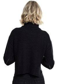 Schwarzer gestrickter Pullover mit kurzem Schnitt, hohem Kragen, weiten Ärmeln und gerippter Struktur. Rückansicht zeigt offene Strickakzente an den Ärmeln.