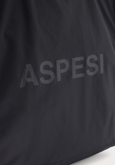 Surface en tissu noir avec le mot « ASPESI » imprimé en grandes lettres gris foncé légèrement brillantes au centre.