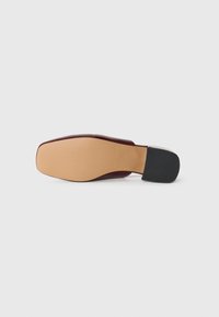Souliers bordeaux avec un design épuré et minimaliste, à bout carré et en cuir lisse. Semelle texturée couleur marron clair avec un talon noir.