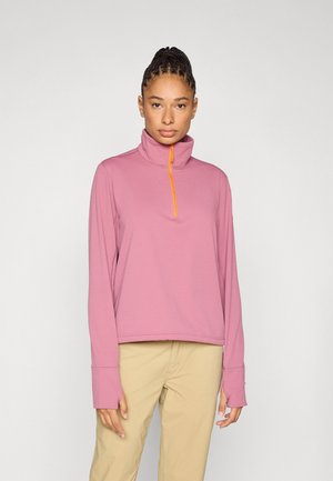 Ανοιχτό ροζ, μακρυμάνικο πουλόβερ με ημιδιάφαντο φερμουάρ και πορτοκαλί τράβηγμα. Διαθέτει ψηλό γιακά και παρατεταμένα μανίκια. Ομαλή υφή.