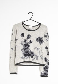 Pull en tricot gris clair avec motif floral noir, col rond, manches longues et une coupe légèrement cropped ; présente des accents de bordures sombres.