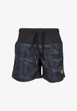 Férfi úszóshort sötét álcázó mintával, fekete derékpánttal, ellasztikus zsinórral és barna címkével az oldalon.