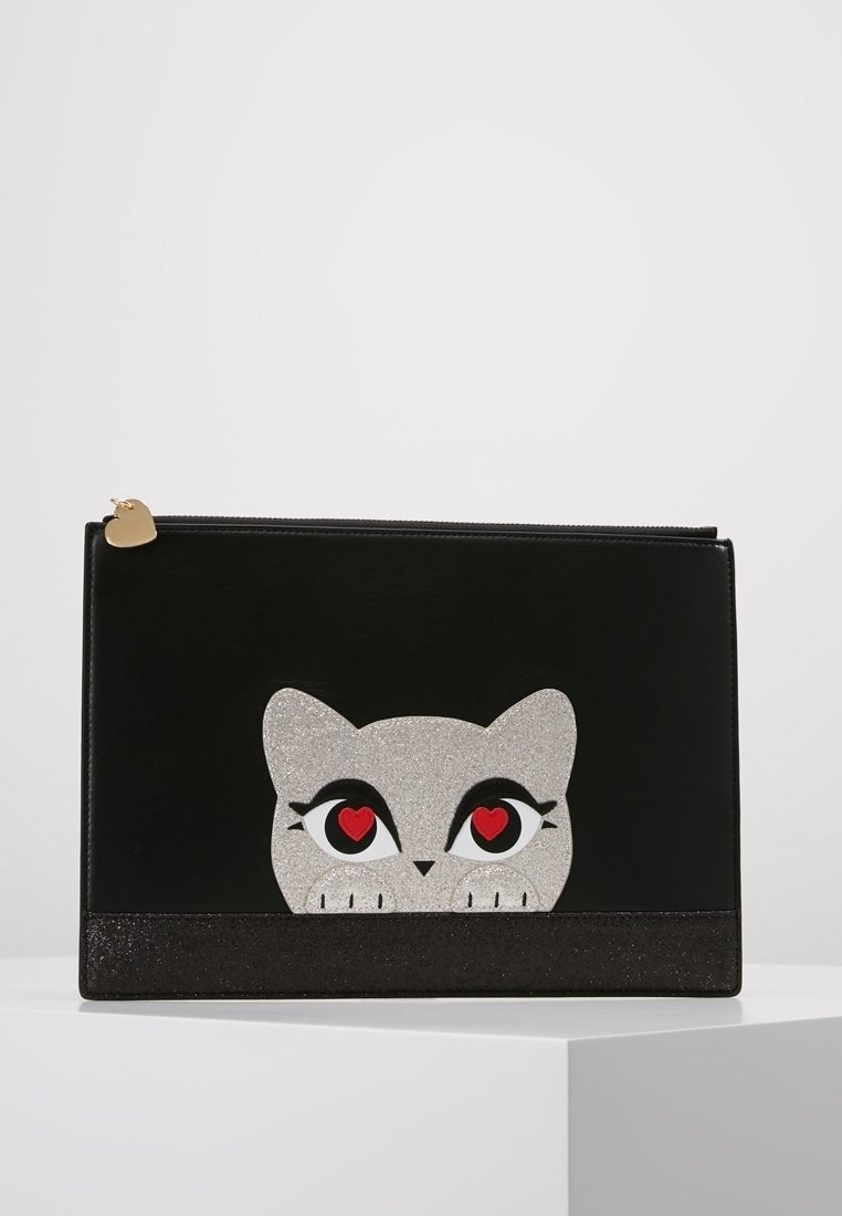 Musta tekonahkainen clutch hopeisella kimaltavalla kissan kasvojen kuvioinnilla. Siinä on punaiset sydämenmuotoiset silmät ja musta kimaltava reuna alareunassa.