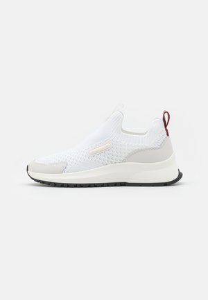 White slip-on sneaker with a textured knit upper, smooth gray accents, pull tab, and a rubber sole featuring a black tread pattern.