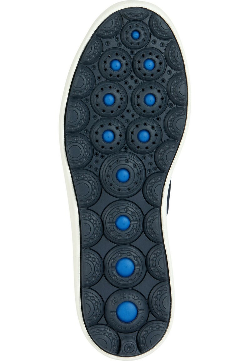 Schuhsohle aus einem Gummi-Material, mit einer schwarzen strukturierten Oberfläche und blauen runden Akzenten. Besonders auffällig ist das mehrfarbige Design.