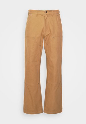 Beige kravu bikses, kas izgatavotas no izturīga auduma, ar sānu kabatām, metāla detaļu akcentiem, taisnu kāju griezumu un parastu vidukli.