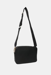 Borsa a tracolla nera in pelle con finitura texturizzata, forma rettangolare, chiusura con zip e tracolla regolabile. Dettagli in hardware dorato.