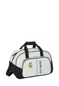 Torba sportowa w białym i czarnym kolorze, z teksturowanym wzorem, górnymi uchwytami, przednią kieszenią na zamek błyskawiczny oraz logo Real Madryt.
