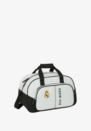 Torba sportowa w białym i czarnym kolorze, z teksturowanym wzorem, górnymi uchwytami, przednią kieszenią na zamek błyskawiczny oraz logo Real Madryt.