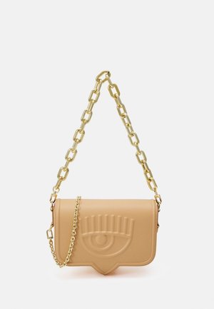 Borsa in finta pelle beige con una forma strutturata, decorata con un design a occhio in rilievo e una tracolla in catena dorata con anelli grandi. Accenti in metallo dorato.