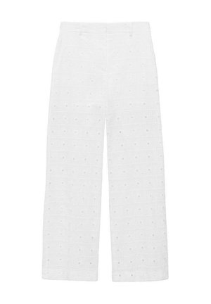 Weiße weit geschnittene Hosen aus strukturiertem Stoff mit Augenlochmustern und quadratischen Motiven sowie runden Ausschnitten.