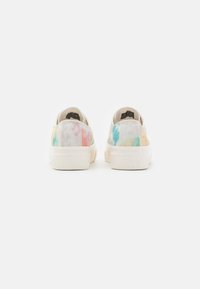 Et par lave canvas sneakers med en hvid sål og et flerfarvet tie-dye mønster, set fra bagsiden på en ensfarvet hvid baggrund.