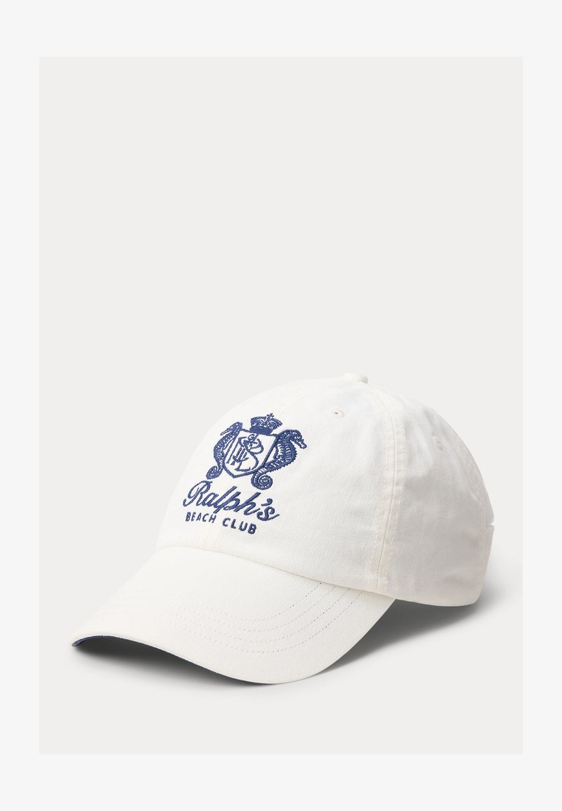 Casquette de baseball blanche avec un écusson brodé bleu marine et le texte "Ralph's Beach Club" sur le devant, visière légèrement courbée.