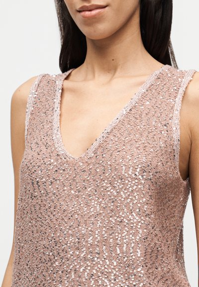 Αμάνικη ροζ μπλούζα με V-λαιμόκοψη, διακοσμημένη με ασημένιες παγιέτες σε υφασμένο μοτίβο. Το ύφασμα έχει μια διακριτική ελαφριά λάμψη.