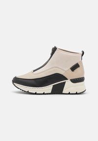 Bottines noires et beiges avec fermeture éclair, tige en synthétique, panneau texturé noir et semelle intermédiaire blanche épaisse et crantée.