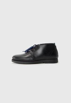Schwarze Lederschuhe mit glatter Textur, niedrigem Knöeldesign und blauen Schnüren. Verfügen über eine schlanke Sohle und dezente Markenkennzeichnung an der Seite.