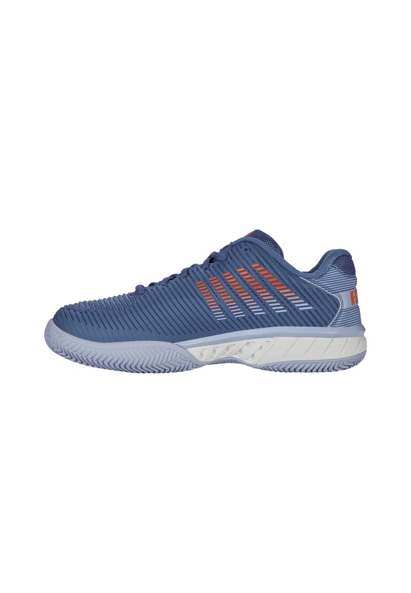 Blue athletic shoe with textured upper, orange accents, and a white sole. Features a breathable design and rubber outsole with a unique pattern.
