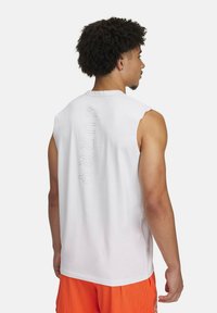 White, sleeveless athletic shirt with "CURRY" embossed vertically on the back. Soft fabric, relaxed fit, paired with orange mesh shorts.