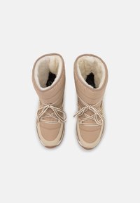 Stivali da neve isolati beige con design trapuntato, fodera in pelliccia sintetica e lacci integrati. Sole robusto con punta arrotondata.
