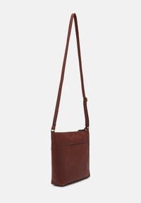 Brun læder crossbody taske med en slank rektangulær form, justerbar rem og en frontlomme. Glat tekstur med en subtil glans.