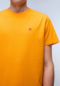 Yellow short-sleeve t-shirt crafted from soft cotton, featuring a small embroidered Norwegian flag on the chest. Smooth texture, crew neck design.