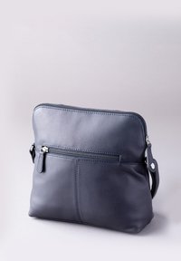 Navy leather bag with a smooth texture, featuring a front zip pocket, top zipper closure, and an adjustable strap. Simple rectangular shape.