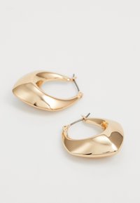Gulltone hoop øreringer med et glatt, bølget design. Har en blank finish og en lås som sikrer sikkert bruk.