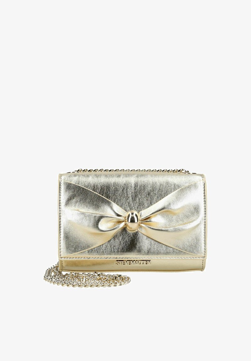 Pochette métallique dorée avec un nœud décoratif au centre et une bandoulière chaîne, marquée "Steve Madden" sur le bord inférieur avant.
